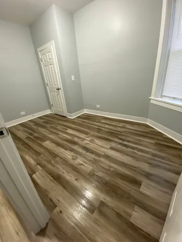 a view of a room with wooden floor and a window