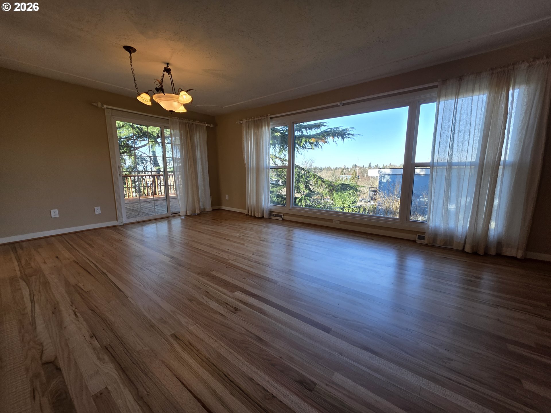 6805 Northeast Multnomah Street Portland, OR 97213 - Photo 7 of 44 an empty room with wooden floor and windows