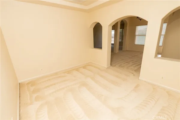 a view of an empty room with a fireplace and a window