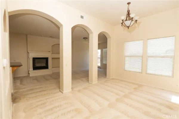 a view of an empty room with a fireplace and a window