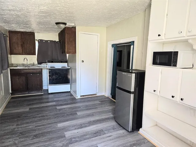 a kitchen with stainless steel appliances kitchen island granite countertop a refrigerator stove and sink