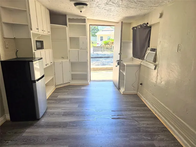 a view of a kitchen with wooden floor and electronic appliances