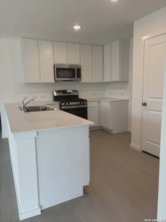 a kitchen with white cabinets and white appliances