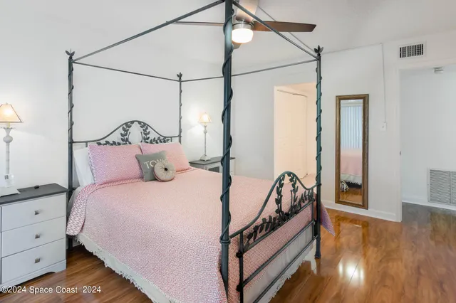 a bedroom with bed and wooden floor