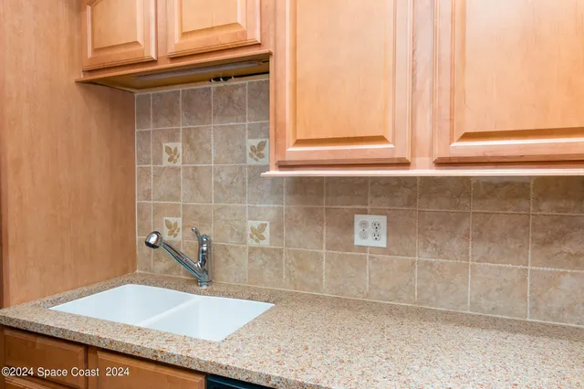 a bathroom with a granite countertop sink and a window