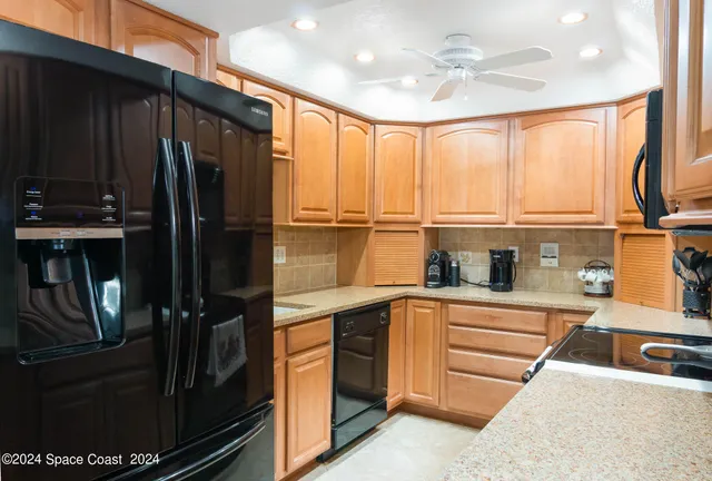 a kitchen with stainless steel appliances granite countertop a refrigerator and a sink