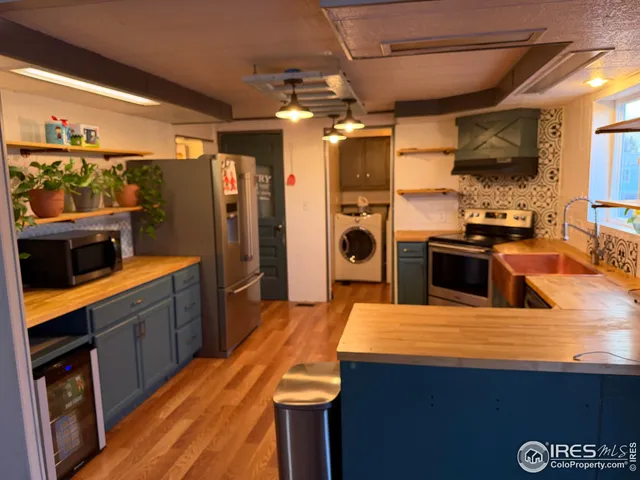 a kitchen with stainless steel appliances kitchen island granite countertop a refrigerator and a stove top oven