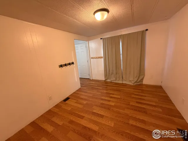 a view of a room with an empty space and wooden floor