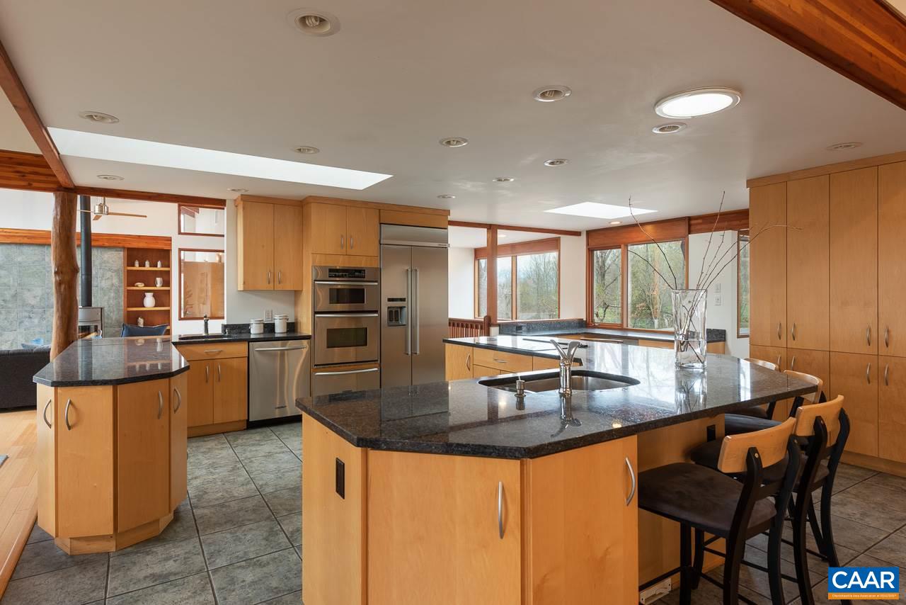 300 Turkey Ridge Road Charlottesville, VA 22903 - Photo 10 of 39 a kitchen with stainless steel appliances granite countertop a stove a sink a microwave a dining table and chairs
