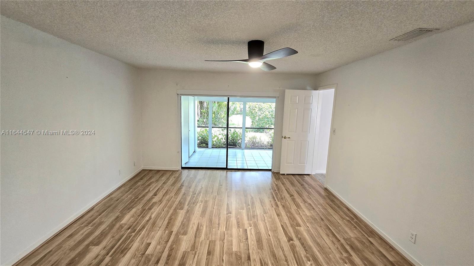 6727 Tiburon Circle Boca Raton, FL 33433 - Photo 11 of 36 an empty room with wooden floor and windows