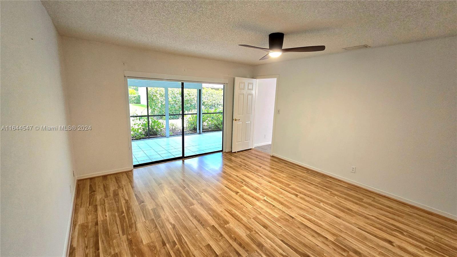 6727 Tiburon Circle Boca Raton, FL 33433 - Photo 10 of 36 a view of an empty room with wooden floor and a window