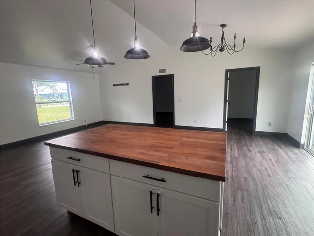 a view of a hallway with a chandelier and wooden floor