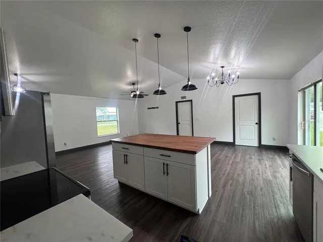 a kitchen with granite countertop a sink a counter space appliances and cabinets