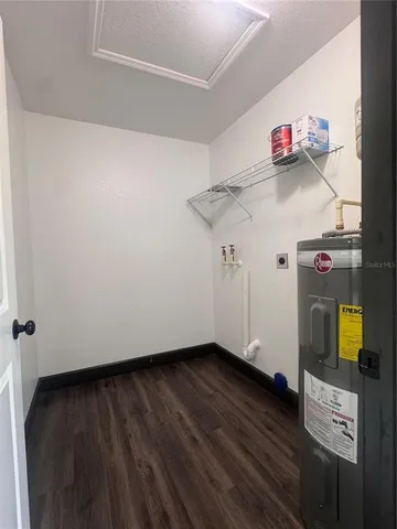 a view of a kitchen with a refrigerator a ceiling fan wooden floor and a kitchen view