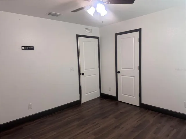 a view of room with hardwood floor and a ceiling fan
