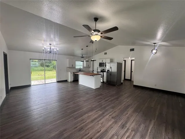 a view of a kitchen with a stove cabinets wooden floor and a ceiling fan
