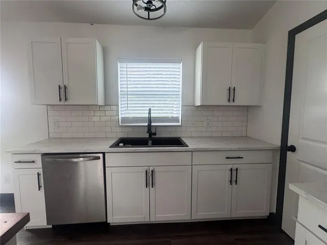 a kitchen with stainless steel appliances granite countertop a sink and a stove