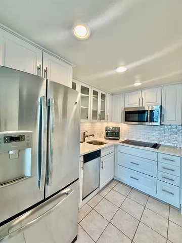 a kitchen with granite countertop stainless steel appliances and white cabinets