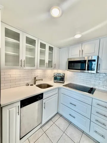 a kitchen with granite countertop white cabinets and white appliances