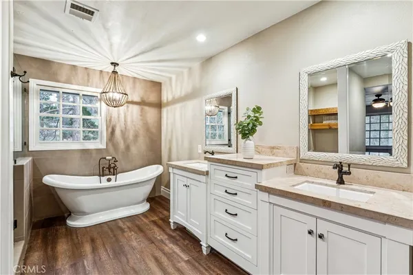 a bathroom with a double vanity sink a mirror and a bathtub