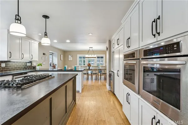 a kitchen with stainless steel appliances granite countertop a stove a sink and a refrigerator