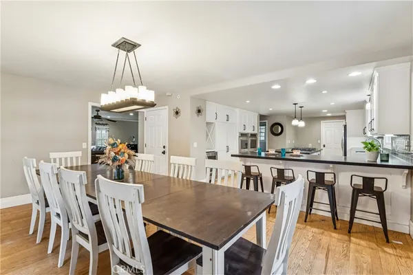 a view of a dining room with furniture a chandelier and wooden floor