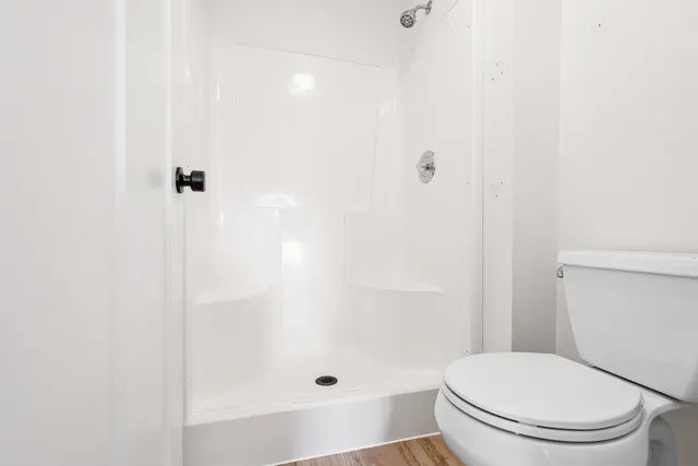 a white toilet sitting next to a bath tub
