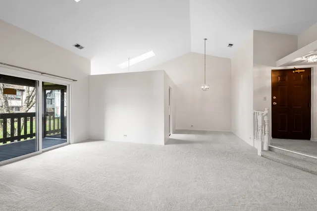 a view of an empty room with glass door and a window