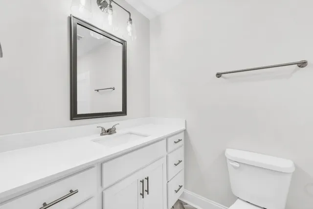 a bathroom with a sink a toilet and a mirror