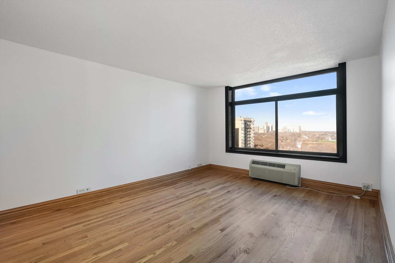 1450 North Astor Street, Unit 15AB Chicago, IL 60610 - Photo 7 of 23 a view of an empty room with wooden floor and a window