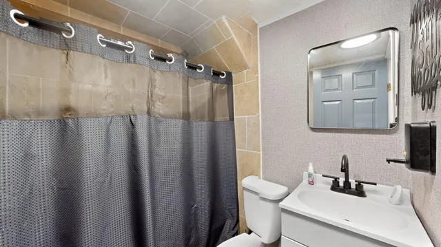a bathroom with a sink a toilet and shower