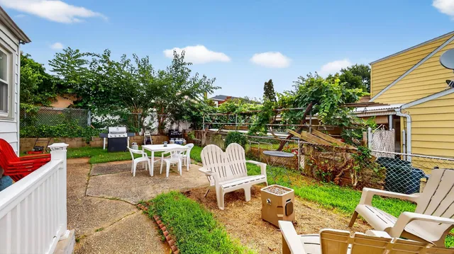 a view of a chair and table in backyard of the house