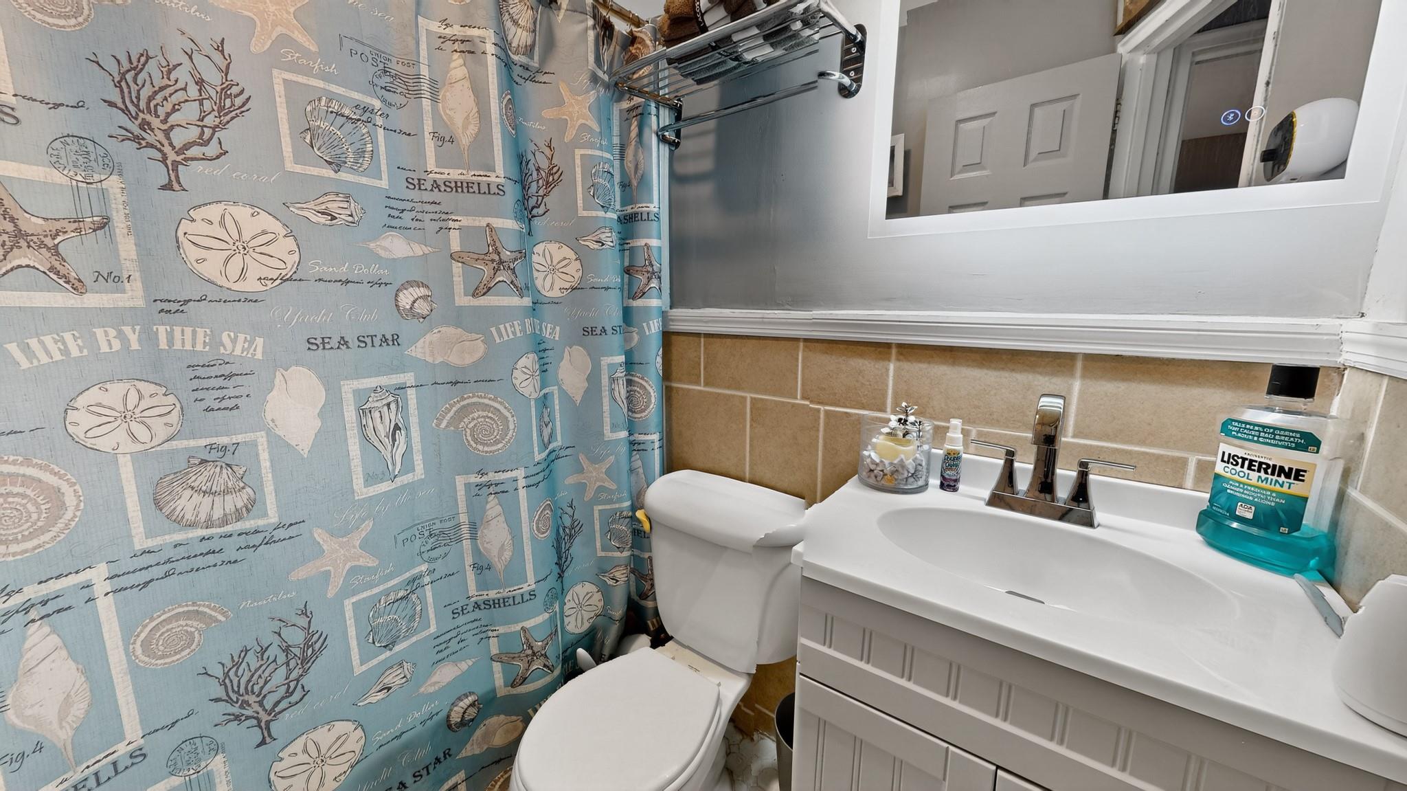 1332 A Street Elmont, NY 11003 - Photo 8 of 19 a bathroom with a toilet sink and shower curtain