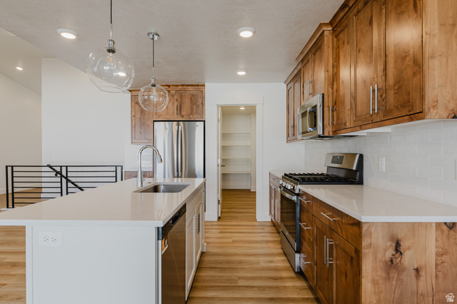 433 North 600 West Smithfield, UT 84335 - Photo 14 of 40 Modern kitchen featuring wood-finish cabinetry, stainless steel appliances, and light-toned countertops