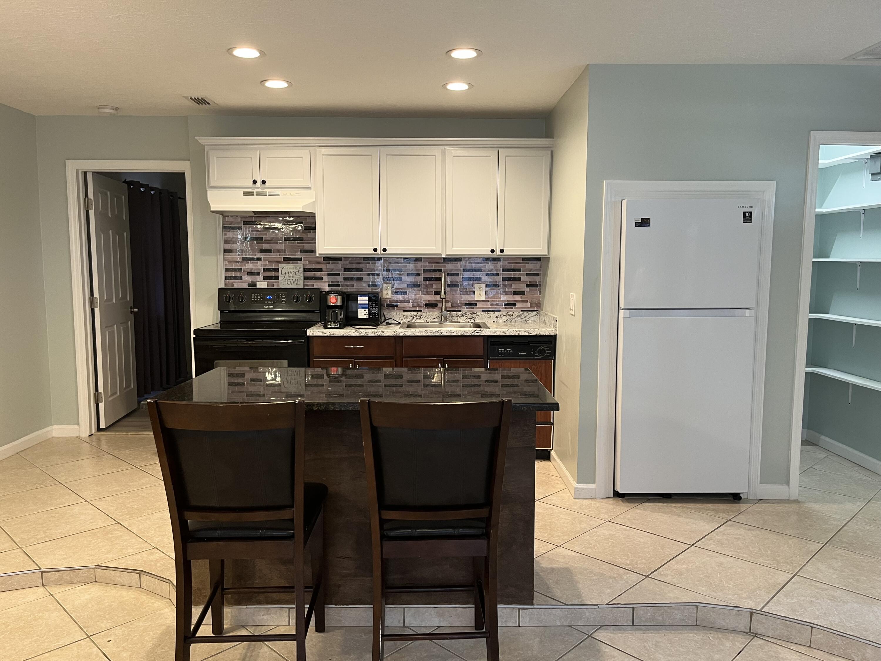 491 Southwest Curtis Street Port St. Lucie, FL 34983 - Photo 2 of 8 a kitchen with a table and chairs