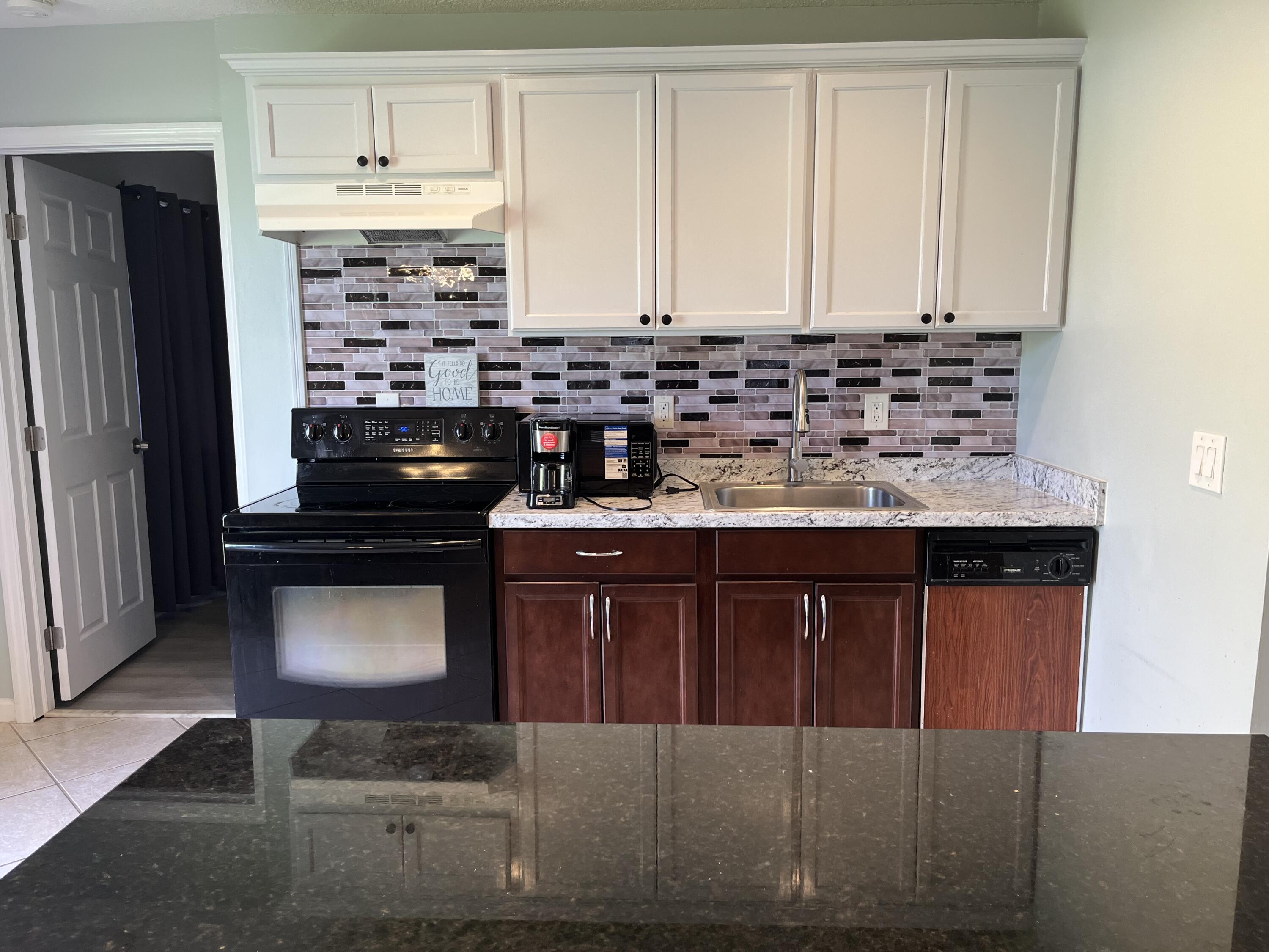 491 Southwest Curtis Street Port St. Lucie, FL 34983 - Photo 3 of 8 a kitchen with stainless steel appliances granite countertop a sink stove and refrigerator