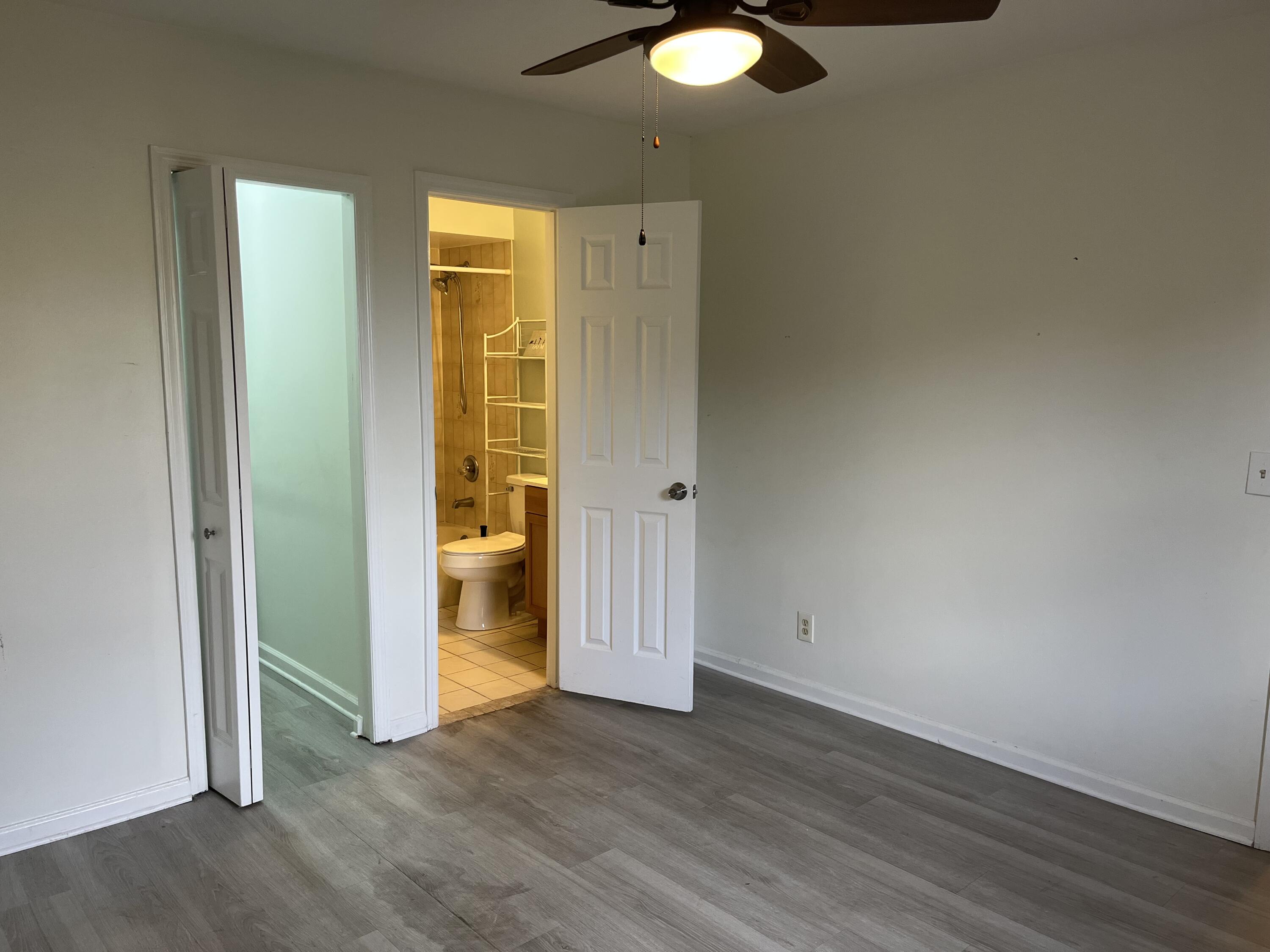491 Southwest Curtis Street Port St. Lucie, FL 34983 - Photo 5 of 8 an empty room with wooden floor and windows