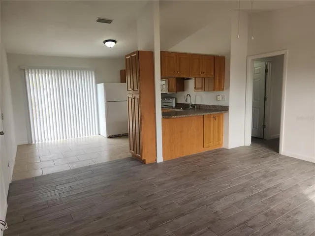 a view of a kitchen with wooden floor and a kitchen