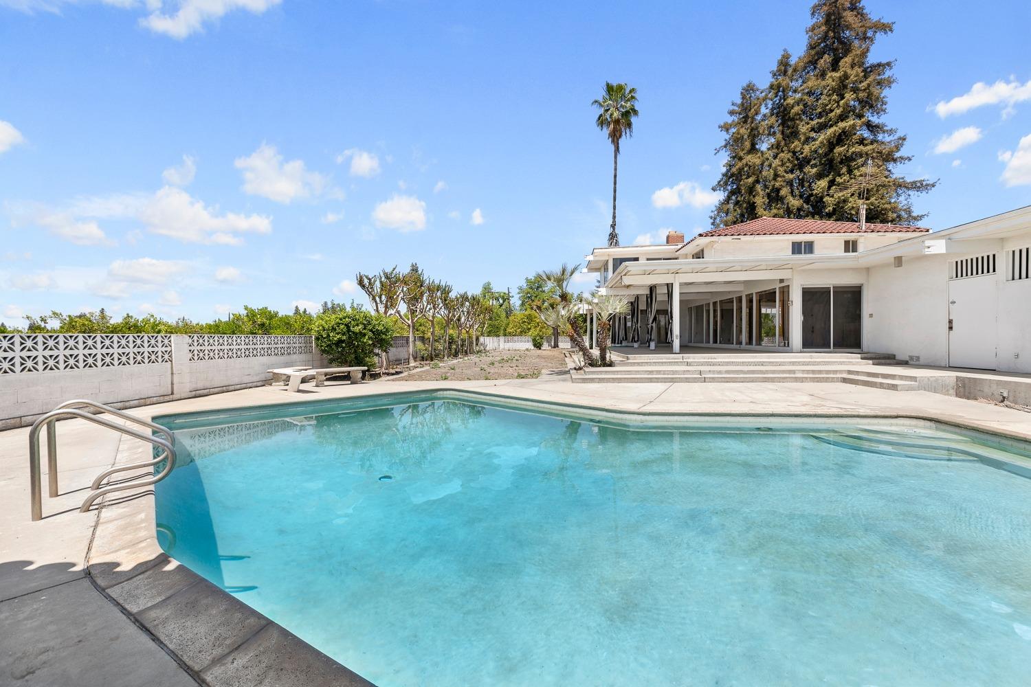 693 South Reed Avenue Reedley, CA 93654 - Photo 50 of 51 a view of a swimming pool with a lawn chairs under an umbrella