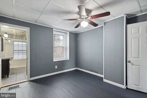 an empty room with closet and a ceiling fan