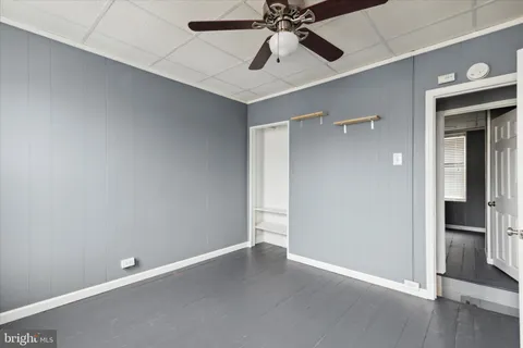 an empty room with a ceiling fan and shower