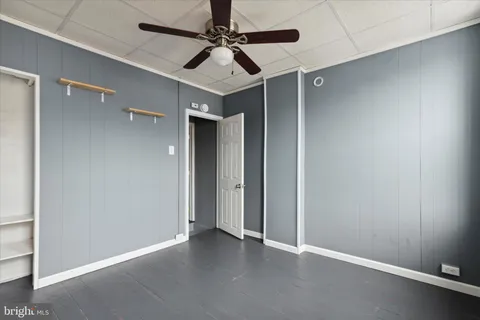 an empty room with windows and fan