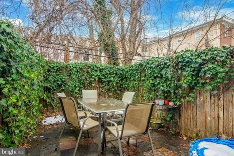 a view of a chairs and table in the backyard