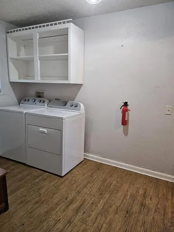 a room with a wooden floor and cabinets