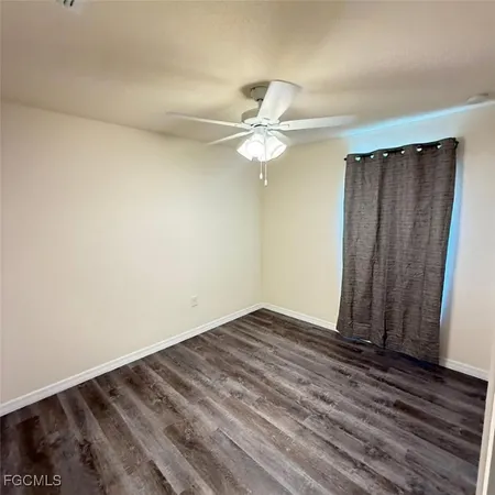 a view of a room with wooden floor and a ceiling fan