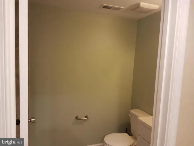 a white toilet sitting next to a white wall