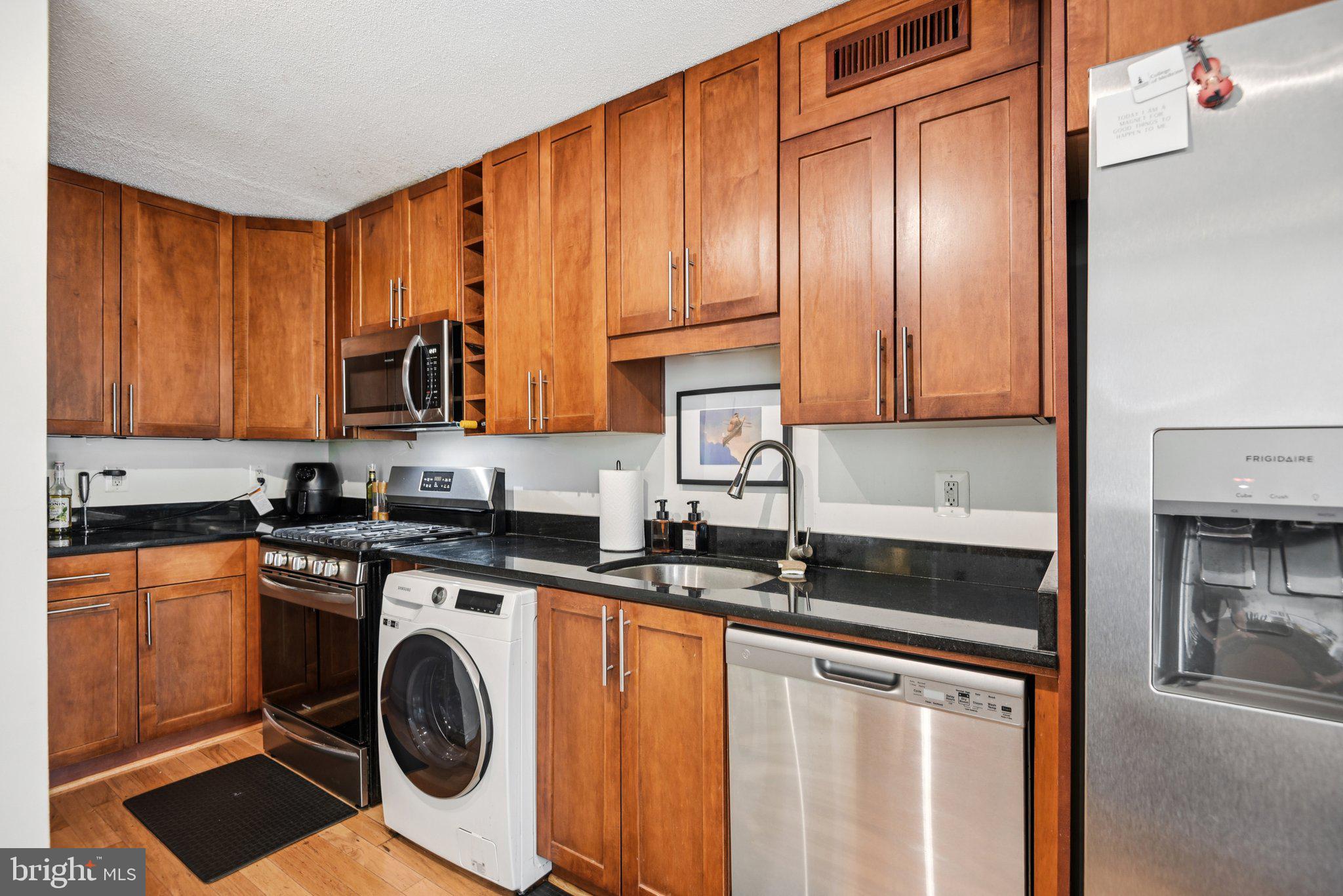 7333 New Hampshire Avenue, Unit 311S Takoma Park, MD 20912 - Photo 18 of 27 a kitchen with stainless steel appliances granite countertop a stove a sink and a microwave