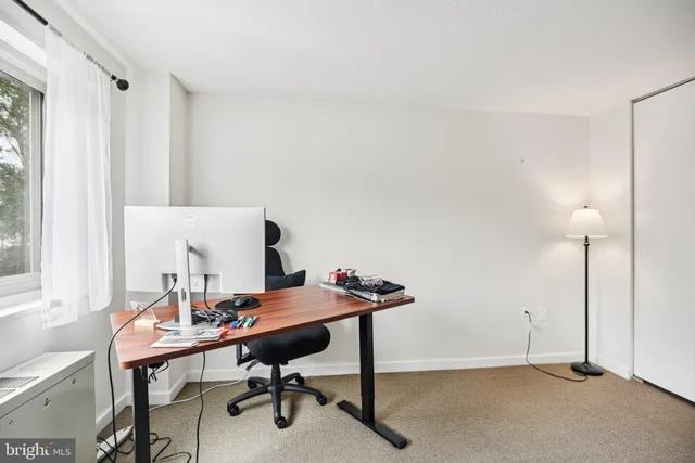 a view of a workspace with furniture and a window