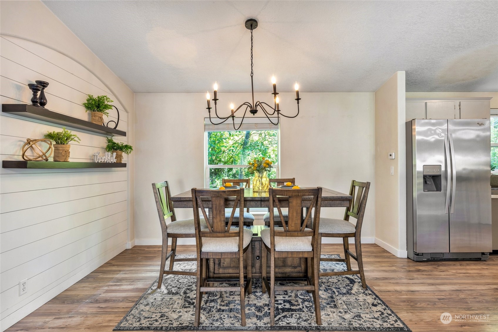 7942 Crockett Road Blaine, WA 98230 - Photo 14 of 33 a view of a dining room with furniture a chandelier and wooden floor