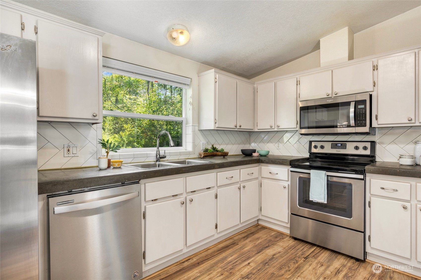 7942 Crockett Road Blaine, WA 98230 - Photo 16 of 33 a kitchen with stainless steel appliances white cabinets a sink and a stove